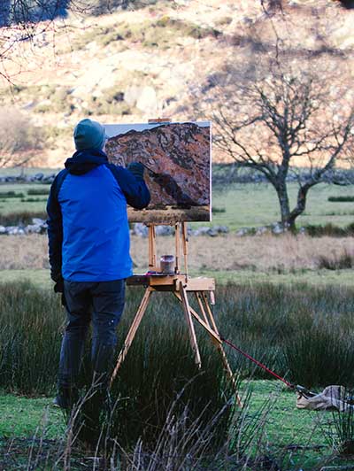 The artist Kieran Guckian at work painting on location in Lough Dan Wicklow.